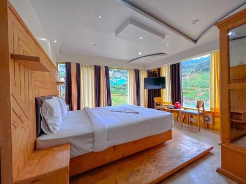 a bedroom with a bed and a large window at Rozana Retreats Ooty in Ooty