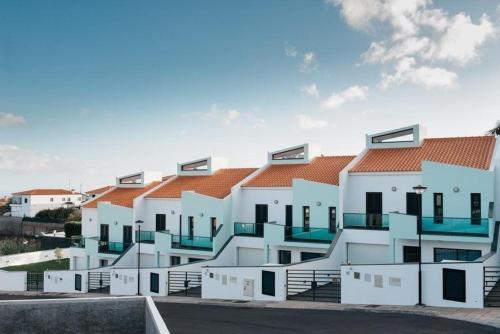 a row of white buildings with orange roofs at Vilas Mediterrâneo in Santa Cruz