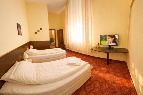 a hotel room with two beds and a table at Комплекс Кремена in Kremena