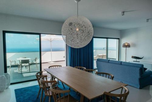a living room with a table and a blue couch at Vilas Mediterrâneo in Santa Cruz
