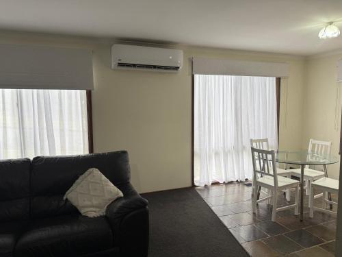 a living room with a black couch and a table at Holiday Home in Drouin in Drouin