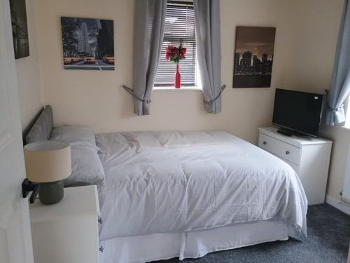 a bedroom with a white bed and a television at Bideawee in Belton