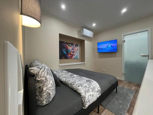 a bedroom with a bed and a tv on the wall at Lumio Apartment 3 - Klimatisiert - Coffee for free - in Karlsruhe