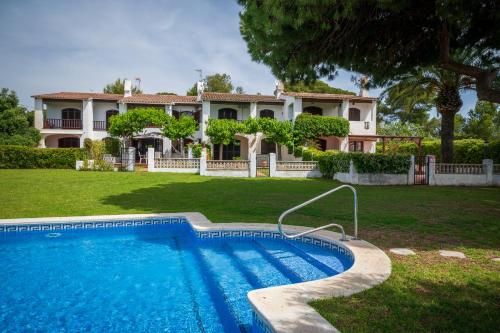a house with a swimming pool in front of a house at AT084 Piscina compartida con 3 casas y vistas al mar in Torredembarra