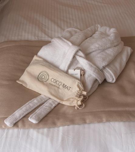 a pile of towels on top of a bed at Triton Hotel Piraeus in Piraeus