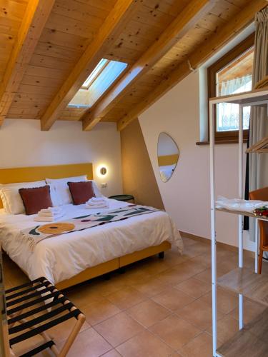 a bedroom with a large bed and a wooden ceiling at Relais Tesino in Castello Tesino