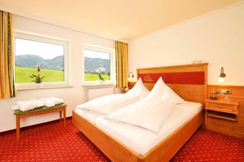 a bedroom with a large bed and a window at Hotel Alpenblick in Fischen