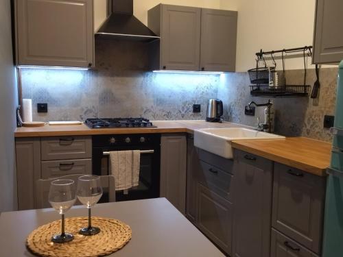 a kitchen with two wine glasses on a table at Cosy Sacz in Nowy Sącz