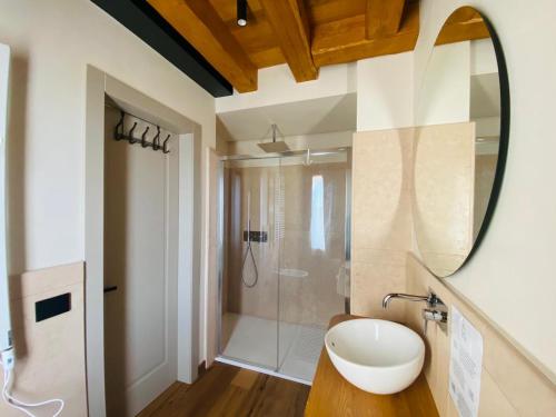 a bathroom with a mirror and a sink and a shower at Casa Tormena in Valdobbiadene