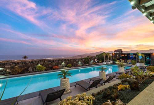 a pool with chairs and a view of the ocean at Exclusive SUPER-SIZE Holiday home - 12 bed,11 bath with Amazing Facilities, Sea and Mountain Views in Tías