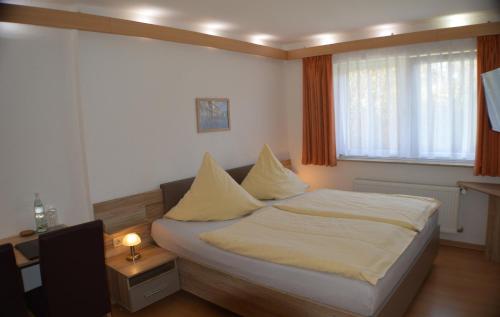 a bedroom with a bed with white sheets and pillows at Hotel und Restaurant Feustel in Plauen