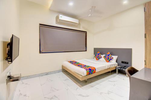 a bedroom with a bed and a screen on the wall at FabHotel Chhappan in Aurangabad