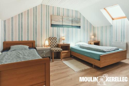 a bedroom with two beds and a chair at Gîte Sieck Moulin de Kerellec in Plougoulm