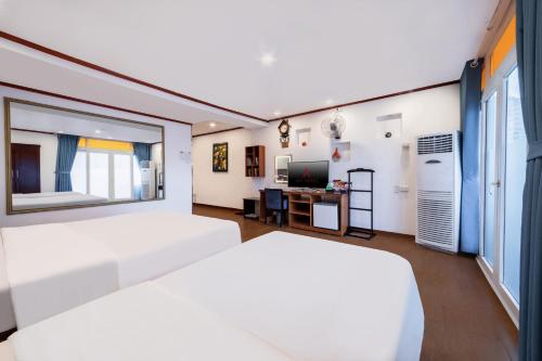 a bedroom with two white beds and a television at A25 Hotel - 46 Châu Long in Hanoi