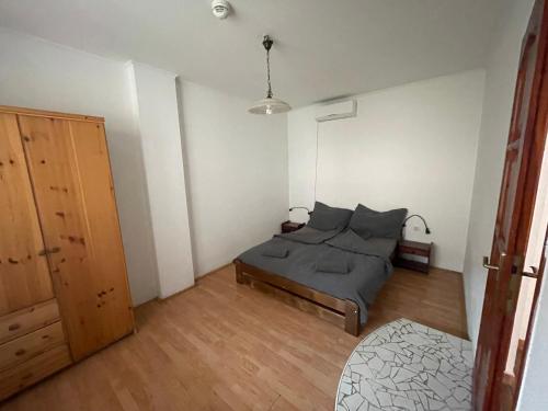 a bedroom with a bed and a wooden floor at Apartman116 Airport in Vecsés