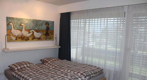 a bedroom with a bed and a picture of birds at Ferienhaus Fisch in Bad Ragaz