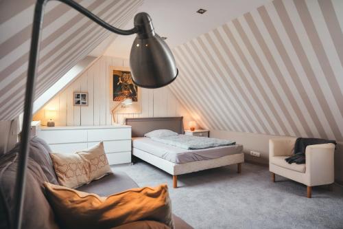 a bedroom with a bed and a chair in a attic at Maison partagée - Moulin de Kerellec in Plougoulm