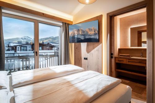 a bedroom with a bed and a large window at Seefeldstub'n in Kirchberg in Tirol