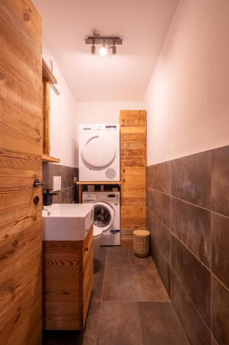 a bathroom with a sink and a washing machine at Arga' New Alpine Design Apartment Central & Scenic Views in San Vito di Cadore