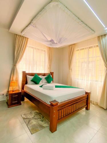 a bedroom with a large bed with green pillows at Nitro Homes Nyali-Coral Sands in Mombasa