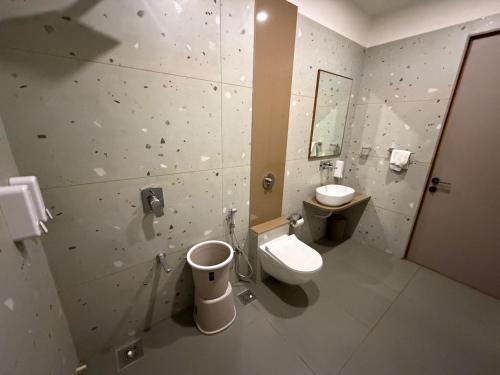 a bathroom with a toilet and a sink at Euphoria The Fine Dine in Surat