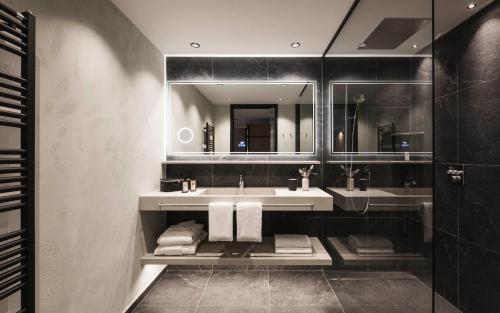 a bathroom with a sink and a mirror at VALARA Alpine Art Hotel in Tux