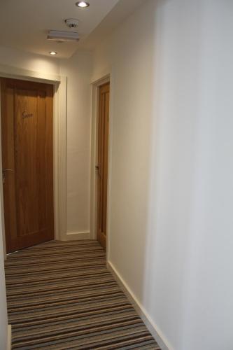 an empty hallway with a door and a carpet at Three Horseshoes Country Inn in Barry