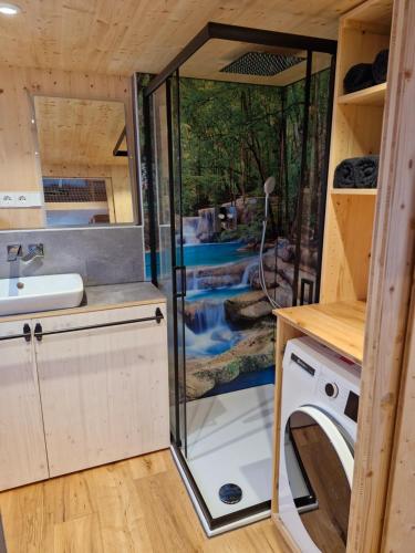 a bathroom with a sink and a washing machine at Tiny House Reichle in Boms