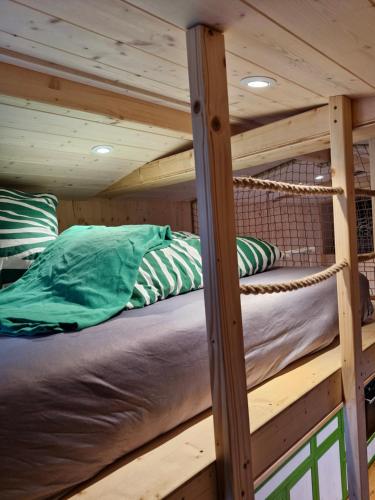 a loft bed in a log cabin with pillows at Tiny House Reichle in Boms