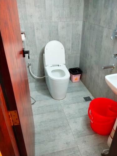 a bathroom with a white toilet and a sink at The Elegance Hotel & Suites in Chittagong