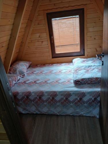 a bedroom with a bed in a log cabin at Villat Loni in Peje