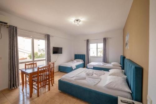 una camera da letto con due letti e un tavolo con un tavolino di Central Garden Sofia Studios a Ksamil