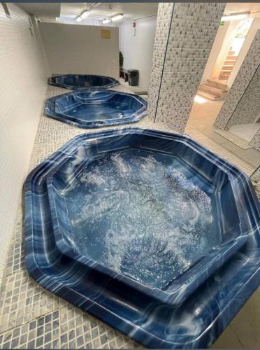 a jacuzzi tub in a room with three blue at Badan Suites & Hotel in Amman