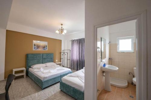una camera d'albergo con due letti e un bagno di Central Garden Sofia Studios a Ksamil