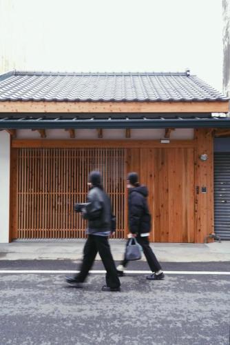 two people walking down a street in front of a building at 弎秋 A chu in Chiayi City