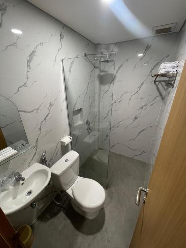 a bathroom with a toilet and a sink and a shower at Agiva Hotel in Kurinci