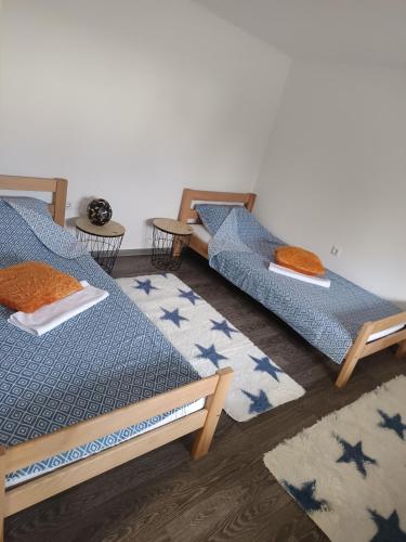 a room with three beds and two rugs at Apartment Lane in Bihać