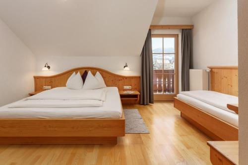 a bedroom with two beds and a window at Kainreiterhof in Aich