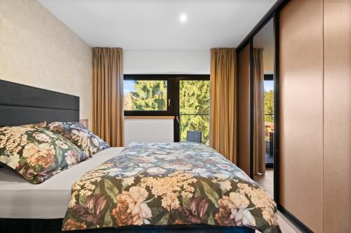 a bedroom with a bed and a large window at Apartmány La Torretta in Harrachov