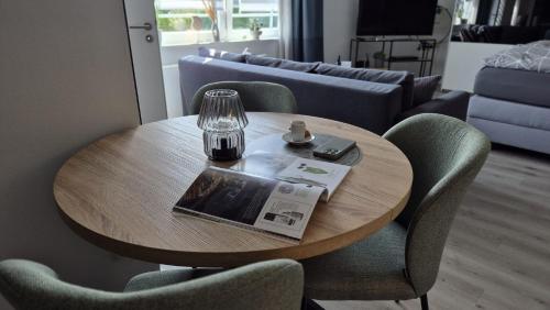 a table with a magazine and a glass on it at Ferienwohnung Villa Grimm in Burbach