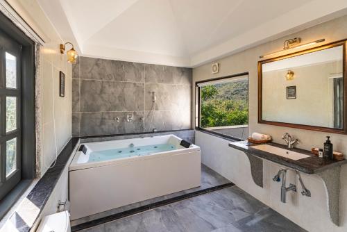 a bathroom with a large tub and a sink at Anandam - A Luxury Resort in Udaipur in Udaipur