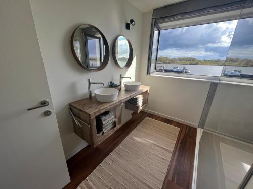 a bathroom with two sinks and a window at Huisje Scheldevallei in Temse