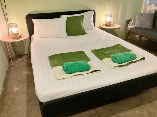 a bed with two green pillows on it at 326 Podtel at The Breakie Bar in Bangkok