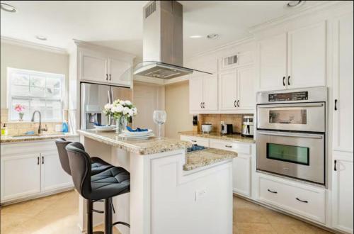 a kitchen with white cabinets and a stove top oven at Lucky House 2 Tranquility in the Middle of Houston in Houston