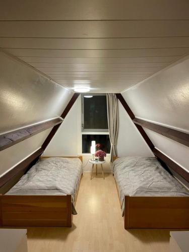 two twin beds in a room with a window at Ferienwohnung Nordholland in Nieuwe-Niedorp