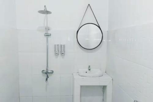 a bathroom with a sink and a mirror on the wall at La Plage Beach Club in Tjikakaka
