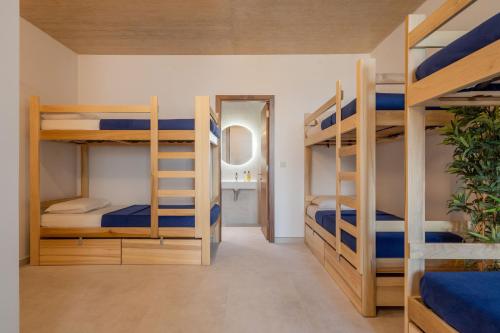 a room with three bunk beds and a mirror at 224 Boutique Hostel in Sliema