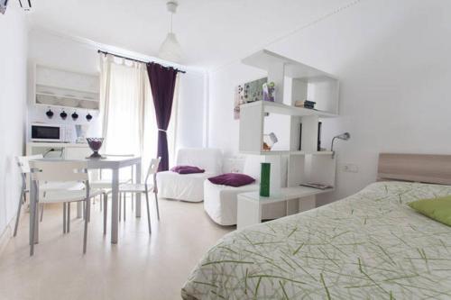 a bedroom with a bed and a table and chairs at Estudios Muñoz in Alicante