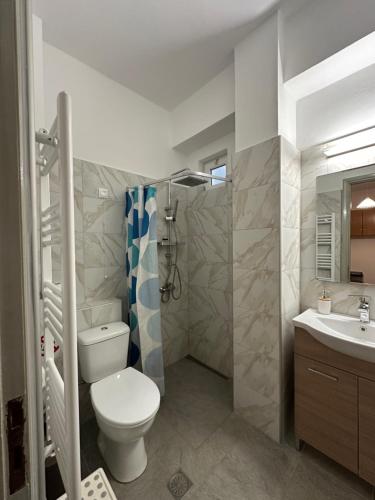 a bathroom with a toilet and a shower and a sink at To Kyma in Amarynthos