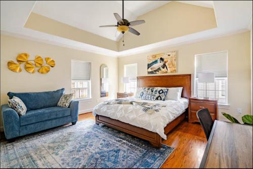 a bedroom with a bed and a chair and a ceiling fan at Lucky House 2 Tranquility in the Middle of Houston in Houston